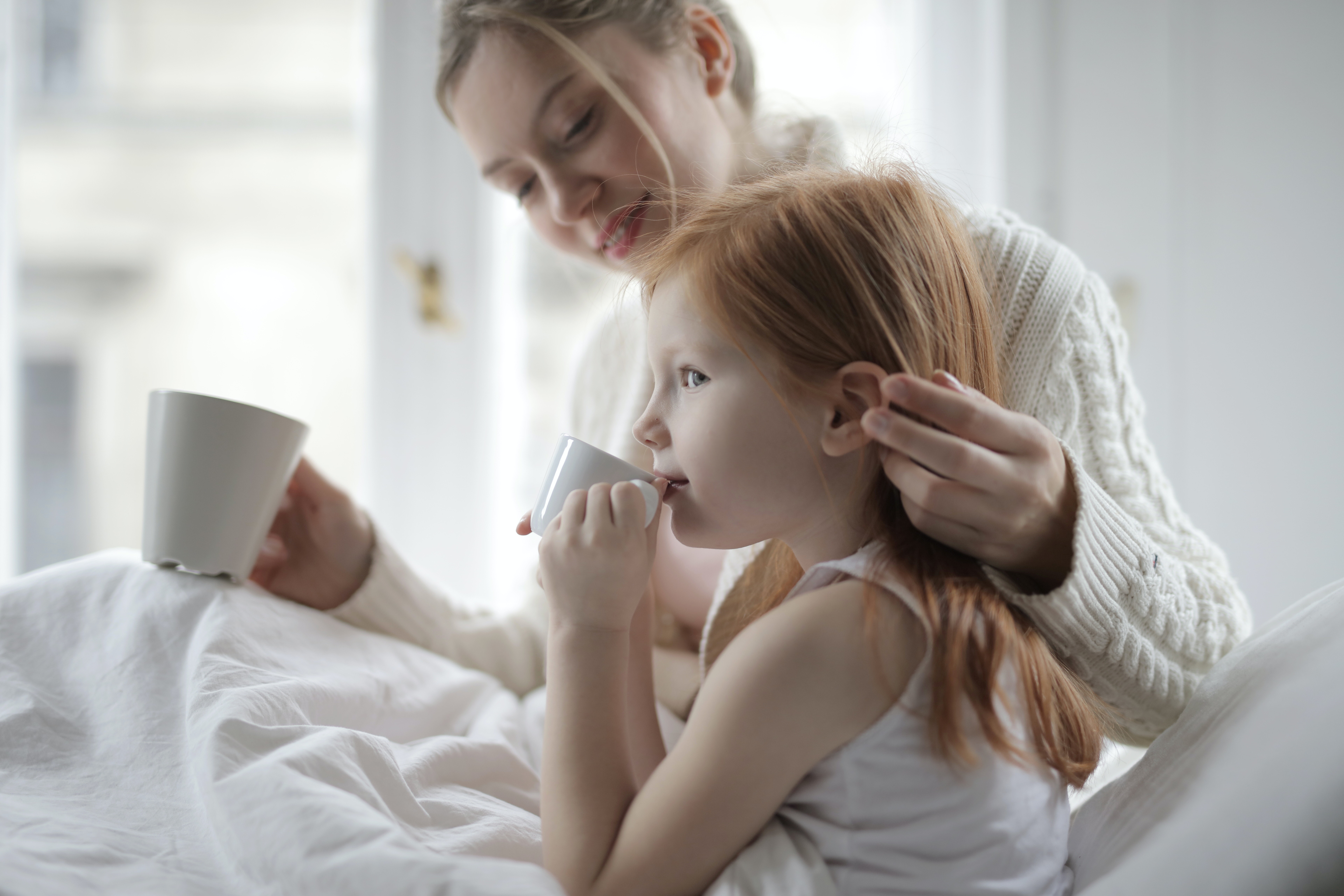 photo of woman holding girl s hair 3890612