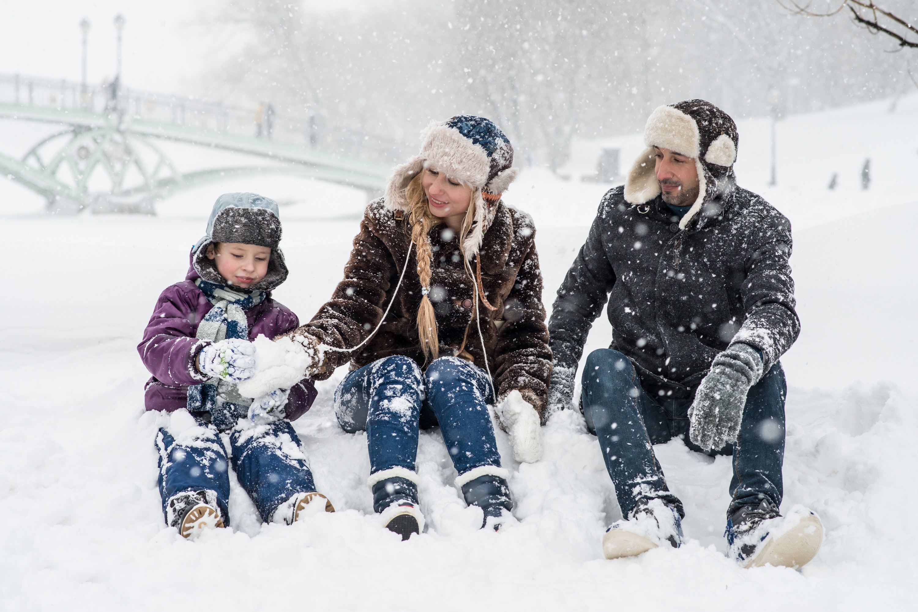 woman man and girl sitting on snow 1620653